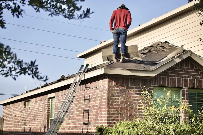 Professional roofer working on a residential roof in Randolphville